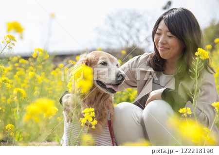 菜の花畑で寄り添う飼い主とゴールデンレトリバー 菜の花畑で寄り添う飼い主とゴールデンレトリバー 122218190