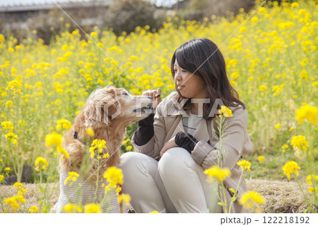 菜の花畑で寄り添う飼い主とゴールデンレトリバー 菜の花畑で寄り添う飼い主とゴールデンレトリバー 122218192