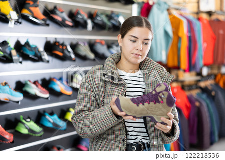 Girl examine compare item of winter comfortable tracking shoes Girl examine compare item of winter comfortable tracking shoes 122218536