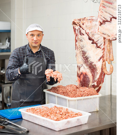Butcher inspecting fresh raw mincemeat ready for sale Butcher inspecting fresh raw mincemeat ready for sale 122218713