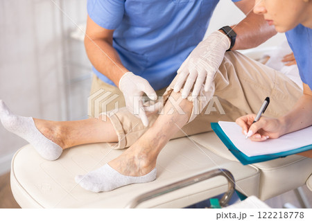 Doctor in medical gloves exam woman's legs. 122218778