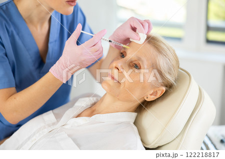 Woman applying rejuvenating treatments by doctor. Woman applying rejuvenating treatments by doctor. 122218817