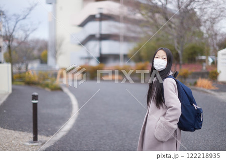 冬の朝の住宅街で通学中の一人の小学生の女の子の姿 122218935
