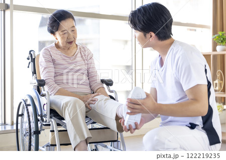 医療　理学療法士から診察を受けるシニア女性 122219235
