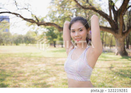 A young woman enjoying nature with a joyful expression on a sunny day in the park. A young woman enjoying nature with a joyful expression on a sunny day in the park. 122219281
