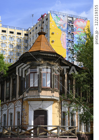 9th-century wooden house with carved architraves and a roof and a modern multi-storey building 122219355