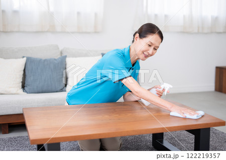 テーブルを掃除するシニア女性のハウスキーパー 122219357