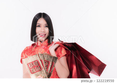 A woman in traditional attire holds lucky money envelopes and a red bag, celebrating joy. A woman in traditional attire holds lucky money envelopes and a red bag, celebrating joy. 122219550