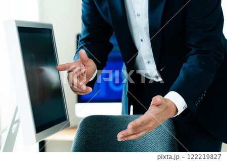 パソコンの前で説明するビジネスマン 122219827