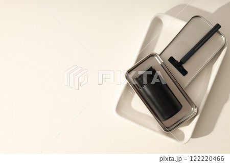 Black bottle and razor on white background, space for text 122220466