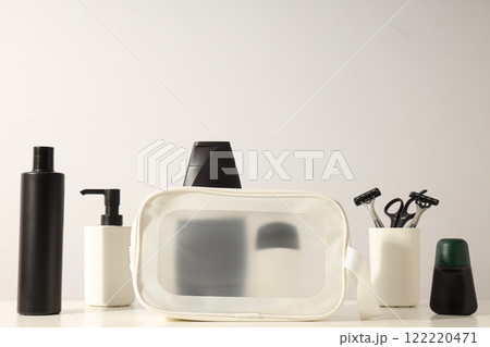 Bottles with men's cosmetics and razors in glass on light background, space for text Bottles with men's cosmetics and razors in glass on light background, space for text 122220471