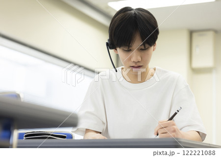 ヘッドセットをつけてテストを受ける学生 ヘッドセットをつけてテストを受ける学生 122221088