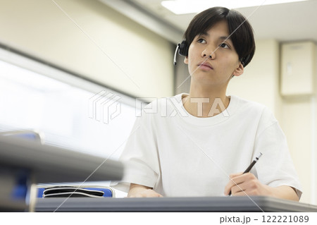 ヘッドセットをつけてテストを受ける学生 122221089