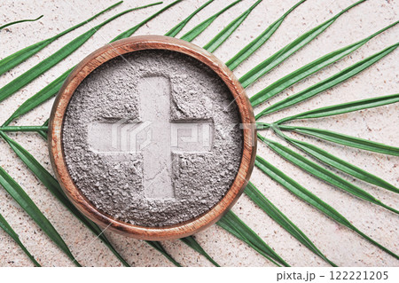 Cross in ashes on a palm leaf background - symbols of Ash Wednesday Cross in ashes on a palm leaf background - symbols of Ash Wednesday 122221205