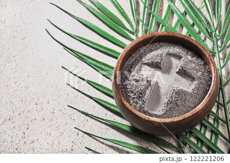 Ash Wednesday. Cross in ashes and palm leaf on stone background Ash Wednesday. Cross in ashes and palm leaf on stone background 122221206