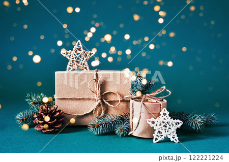 Festive christmas gift boxes with pinecones and stars on sparkling background Festive christmas gift boxes with pinecones and stars on sparkling background 122221224