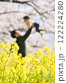 桜と菜の花の中で親が子供を抱っこ 122224280