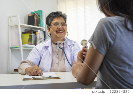 General practitioner taking notes when talking to female patient in hospital. General practitioner taking notes when talking to female patient in hospital. 122224823