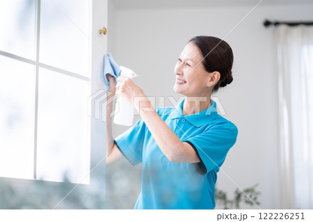 窓を掃除するシニア女性のハウスキーパー 122226251