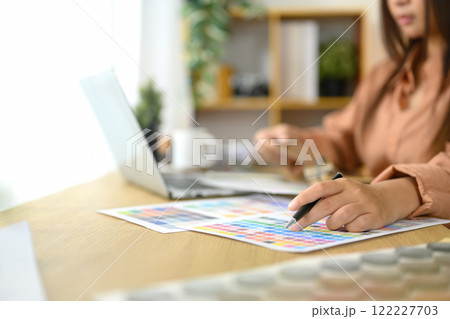 Close up of interior designer reviewing color swatches and design layouts on her desk 122227703