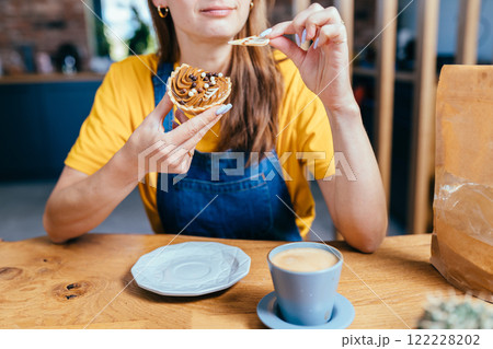 Searching for best advice. Romantic brunette haired smiling female gardener eats sweet cake, drinking coffee sitting surround her plants pots, equipment, tools watering can in home garden at home. Searching for best advice. Romantic brunette haired smiling female gardener eats sweet cake, drinking coffee sitting surround her plants pots, equipment, tools watering can in home garden at home. 122228202
