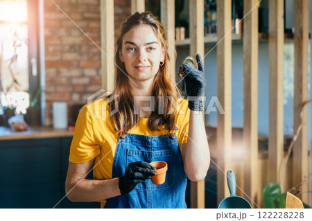 Portrait of successful happy house wife wearing black gloves and casual clothes enjoy work at home modern interior. Concept of home garden. Spring time. Portrait of successful happy house wife wearing black gloves and casual clothes enjoy work at home modern interior. Concept of home garden. Spring time. 122228228