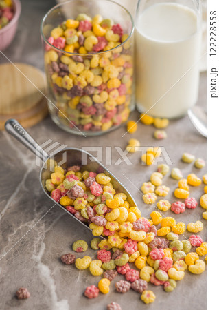 Colorful breakfast cereals in the shape of various fruit on scoop on kitchen table. 122228558