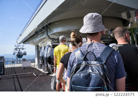Group of adults queuing for gondola ride in summer mountains Group of adults queuing for gondola ride in summer mountains 122228575