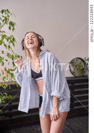 Young caucasian female enjoying music with headphones in a relaxed indoor 122228643