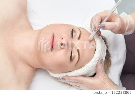 Caucasian adult female receiving botox injection in forehead at beauty clinic 122228863