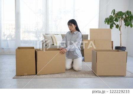段ボールを組み立てて引っ越し作業をする女性 122229233