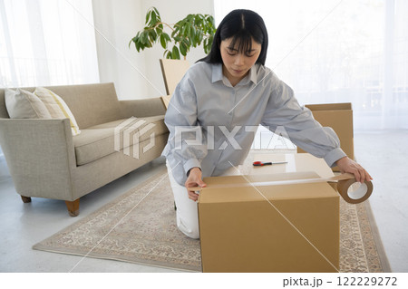 段ボールを組み立てて引っ越し作業をする女性 122229272