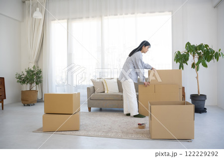 段ボールを組み立てて引っ越し作業をする女性 122229292