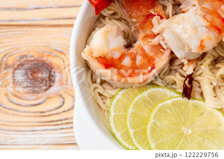 Tom yum soup with shrimps instant noodles and lime photography . Asian food . Top view Tom yum soup with shrimps instant noodles and lime photography . Asian food . Top view 122229756