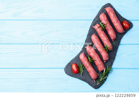 Raw beef sausages with rosemary and tomatoes photography . Top view Raw beef sausages with rosemary and tomatoes photography . Top view 122229859