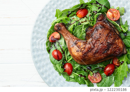 Grilled chicken legs with tomatoes and salad . Top view 122230186