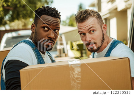 A portrait of two workers carrying boxes out of a van against the background of green trees of a country house, a funny postcard about careful delivery of your goods and a transport company 122230533