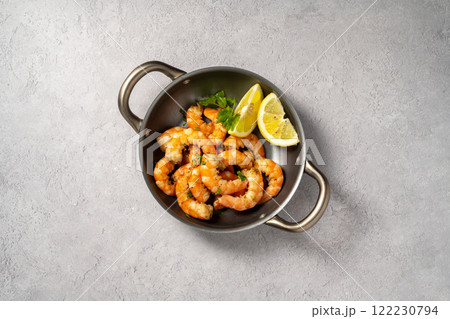 Cooked red prawn with spices in a pan, served with fresh herbs and lemon Cooked red prawn with spices in a pan, served with fresh herbs and lemon 122230794