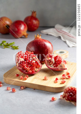 Fresh pomegranates, ripe red pomegranate slices on cutting board. 122230885