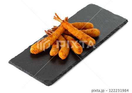 Five deep fried golden shrims at lava stone board isolated at white background. 122231984