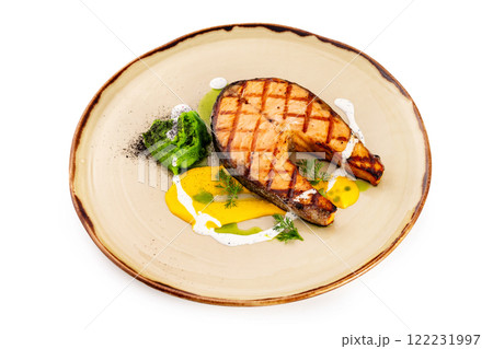 Plate of grilled salmon fish steak served with cream sauce isolated at white background. Plate of grilled salmon fish steak served with cream sauce isolated at white background. 122231997