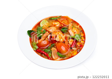 Closeup plate of traditional thai soup - tom yum kung with shrimps and tomatoes isolated at white background. 122232011