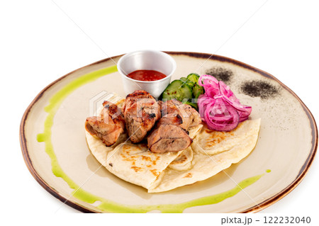Plate with pork meat shashlik - traditional barbecue meal served with lavash, vegetables and ketchup isolated at white background. Plate with pork meat shashlik - traditional barbecue meal served with lavash, vegetables and ketchup isolated at white background. 122232040