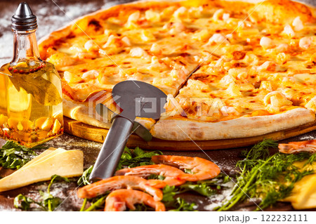 Tasty italian pizza with fresh golden cheese, shrimps and olive oil at wooden background. 122232111