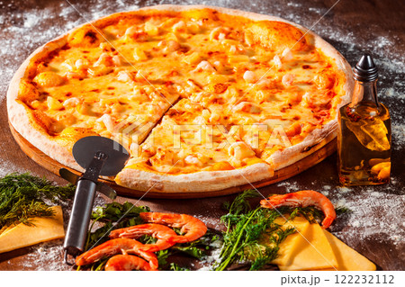 Tasty italian pizza with fresh golden cheese, shrimps and olive oil at wooden background. 122232112