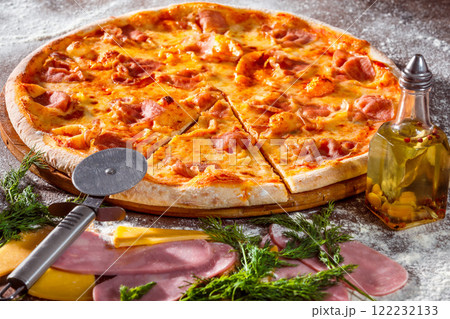 Closeup image of tasty italian pepperoni pizza with ham at wooden table background. 122232133