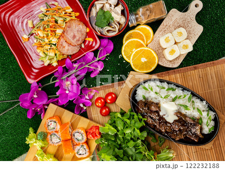 Top view flatlay japanese style business lunch including soup, salad, dessert and main meal at green grass decorated background. Top view flatlay japanese style business lunch including soup, salad, dessert and main meal at green grass decorated background. 122232188