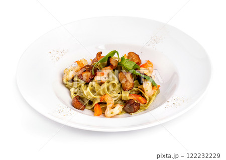 Plate of tasty seafood tagliatelle pasta with salmon and shrimps isolated at white background. Plate of tasty seafood tagliatelle pasta with salmon and shrimps isolated at white background. 122232229