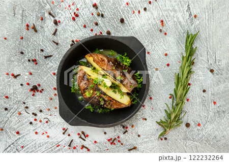 Pan of baked potatoes with butter at concrete textured talbe background. with spices around. Pan of baked potatoes with butter at concrete textured talbe background. with spices around. 122232264