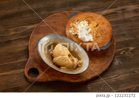 Traditional american apple pie served on a wooden tray and decorated with icecream at wooden table background. Traditional american apple pie served on a wooden tray and decorated with icecream at wooden table background. 122232272